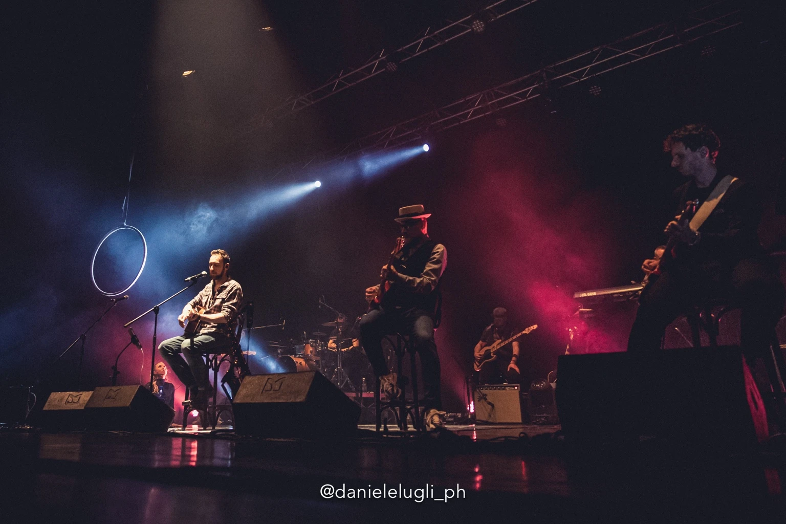 La band in formazione acustica sul palco, accanto al cerchio per la danza aerea